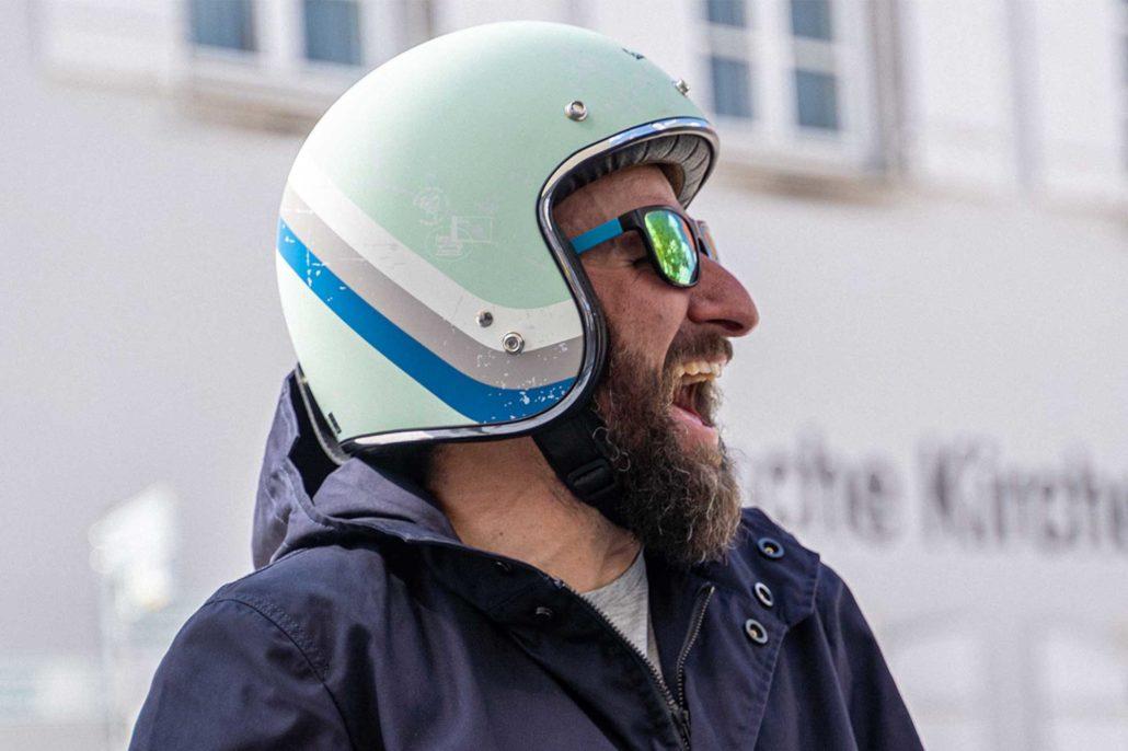 Vespa-Fahrer mit CADUFF Schleifschutz-Parka und türkisfarbenem Helm beim Vespa-Treffen 2025 in der Schweiz, Deutschland oder Österreich Vespa rider wearing CADUFF abrasion-resistant parka and turquoise helmet at a 2025 Vespa meeting in Switzerland, Germany or Austria